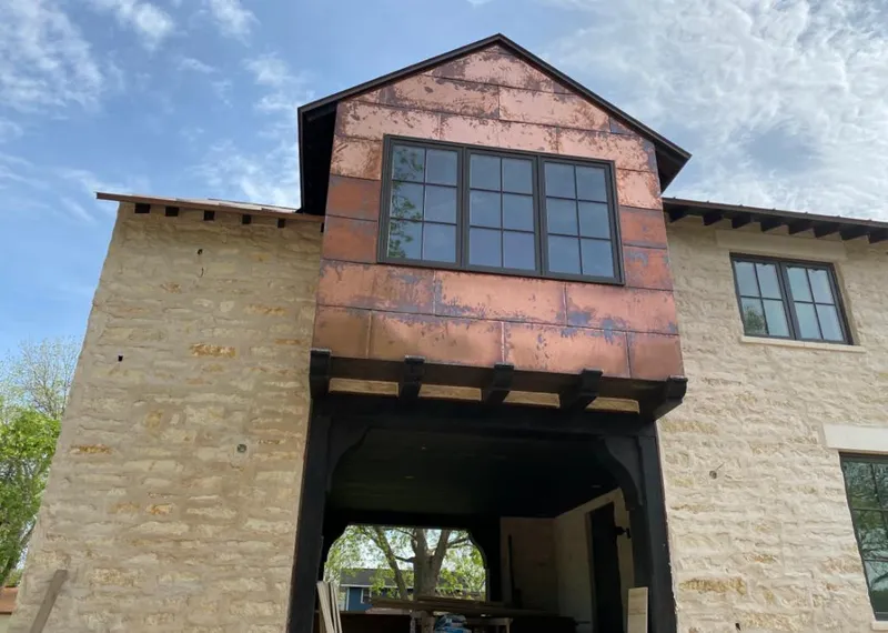 Copper metal panel facade on a stone building for Skylight Installation in Cedar Lake